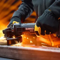 Esmerilhadeira elétrica DeWalt em operação sobre estrutura metálica